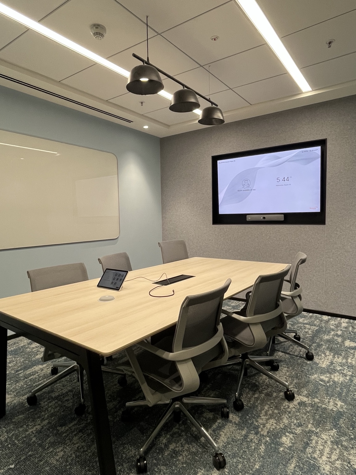 A meeting room with an integrated display and video bar, plus convenient table controls.